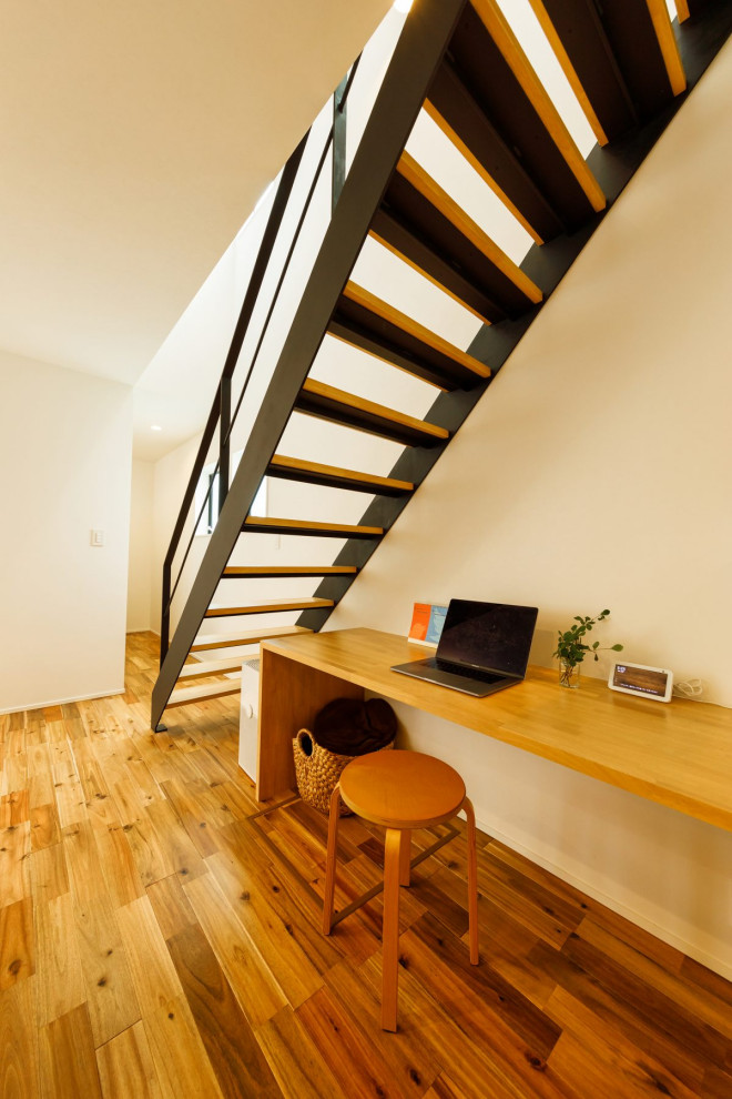 На фото: прямая лестница среднего размера в стиле лофт с деревянными ступенями, металлическими перилами и обоями на стенах с