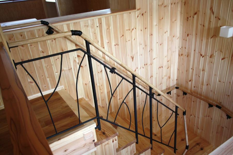 Cette photo montre un escalier scandinave en U avec des marches en bois, des contremarches en bois, un garde-corps en métal et boiseries.
