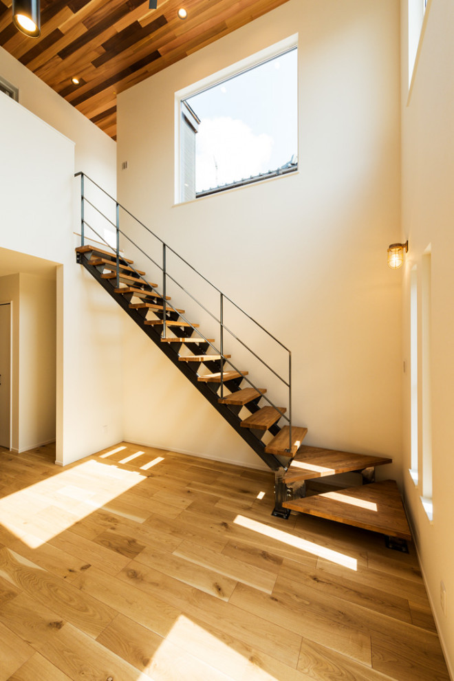 Cette photo montre un escalier sans contremarche bord de mer en L avec des marches en bois, un garde-corps en métal et du papier peint.