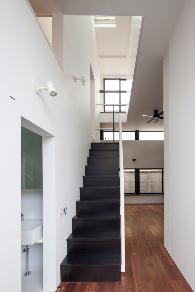 Foto de escalera recta minimalista con escalones de madera, contrahuellas de madera y barandilla de metal