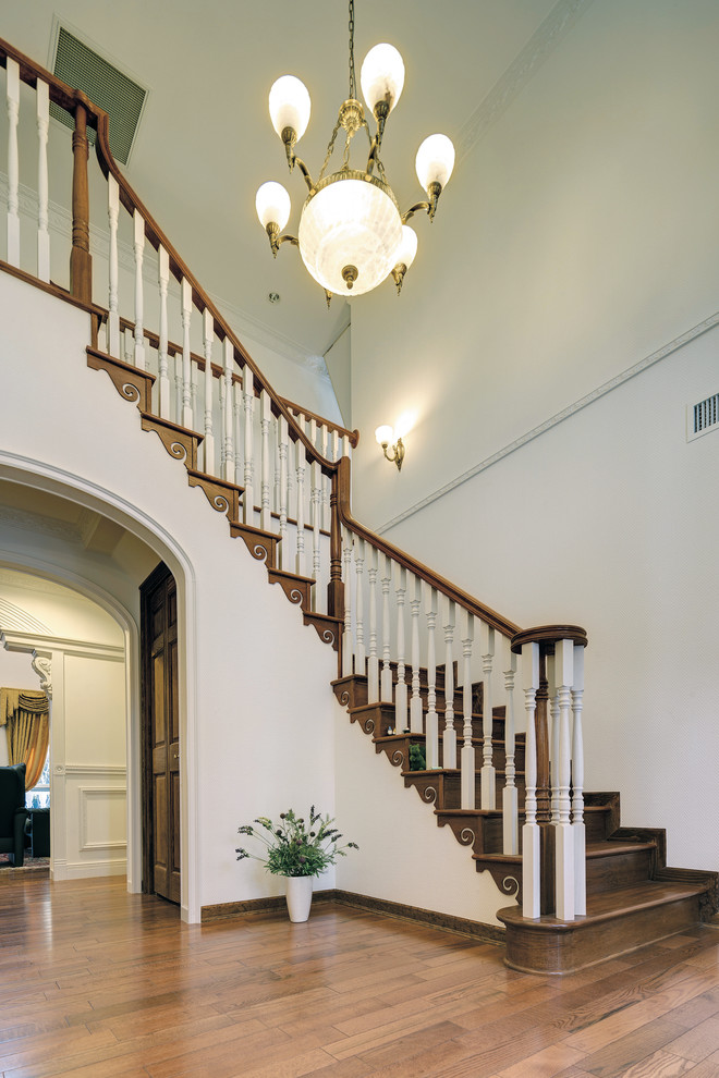 Réalisation d'un grand escalier tradition en marbre avec des contremarches en bois.