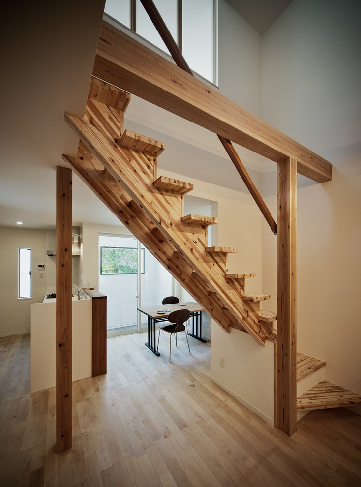 На фото: прямая лестница в скандинавском стиле с деревянными ступенями и деревянными перилами без подступенок