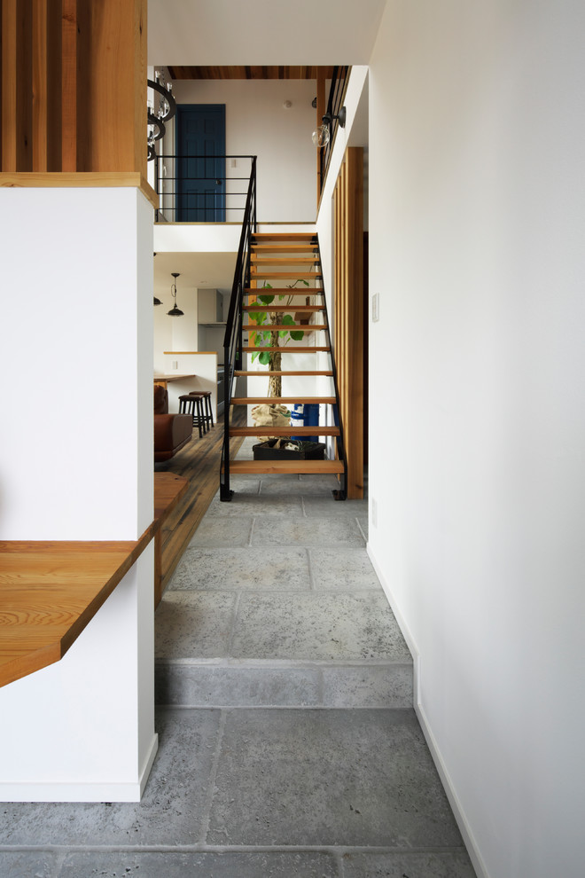 На фото: прямая лестница в стиле лофт с деревянными ступенями и металлическими перилами без подступенок