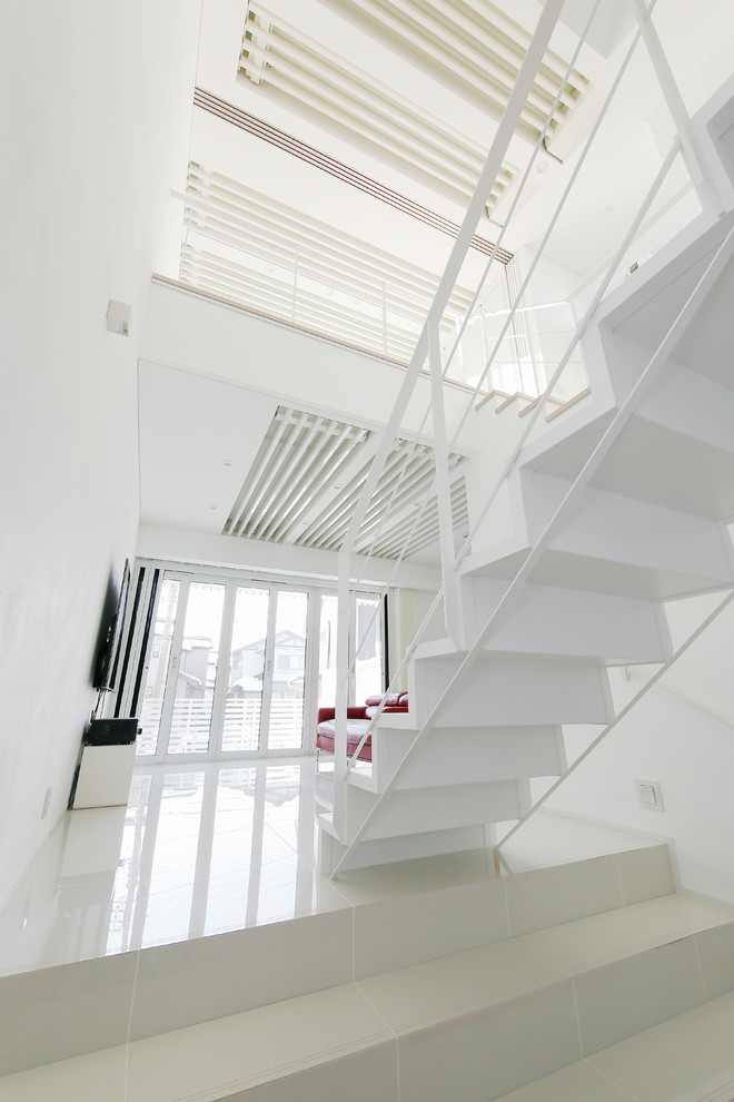 Foto de escalera minimalista con escalones de madera, contrahuellas de madera y barandilla de metal