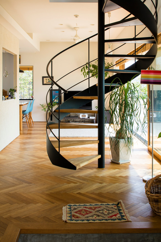 Aménagement d'un escalier sans contremarche hélicoïdal contemporain avec des marches en bois.
