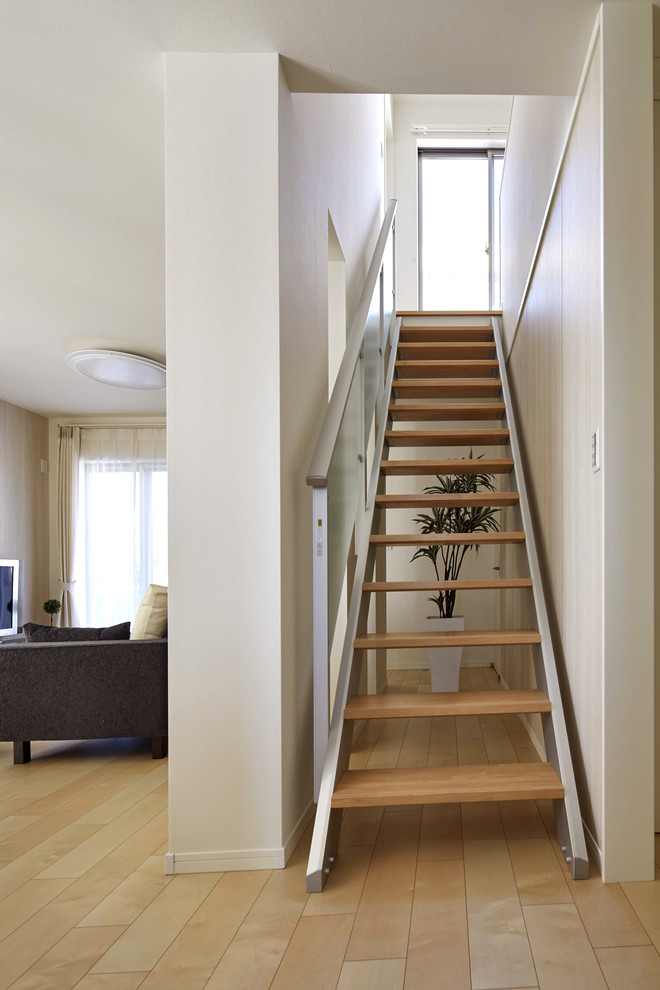 Ejemplo de escalera recta actual sin contrahuella con escalones de madera y barandilla de metal