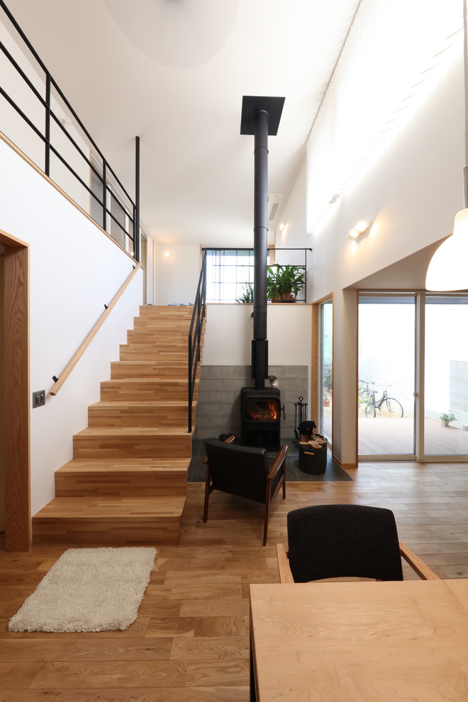 Inspiration pour un escalier droit nordique de taille moyenne avec des marches en bois, des contremarches en bois, un garde-corps en bois et du papier peint.