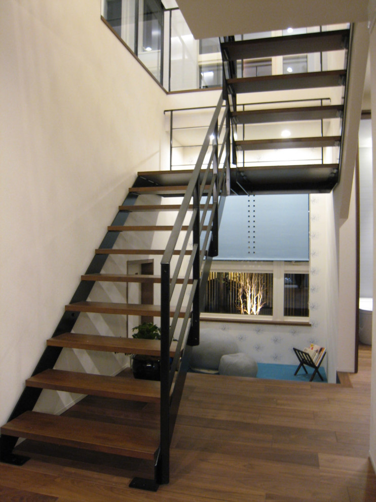 Exemple d'un escalier sans contremarche rétro en U de taille moyenne avec des marches en bois et un garde-corps en métal.