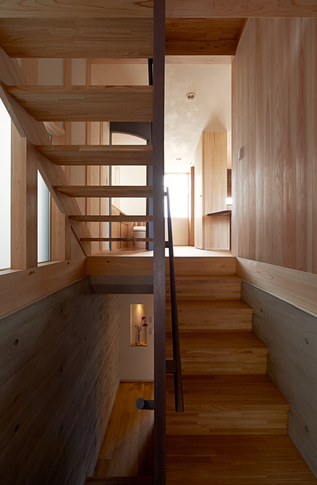 На фото: п-образная деревянная лестница в стиле модернизм с деревянными ступенями и деревянными перилами