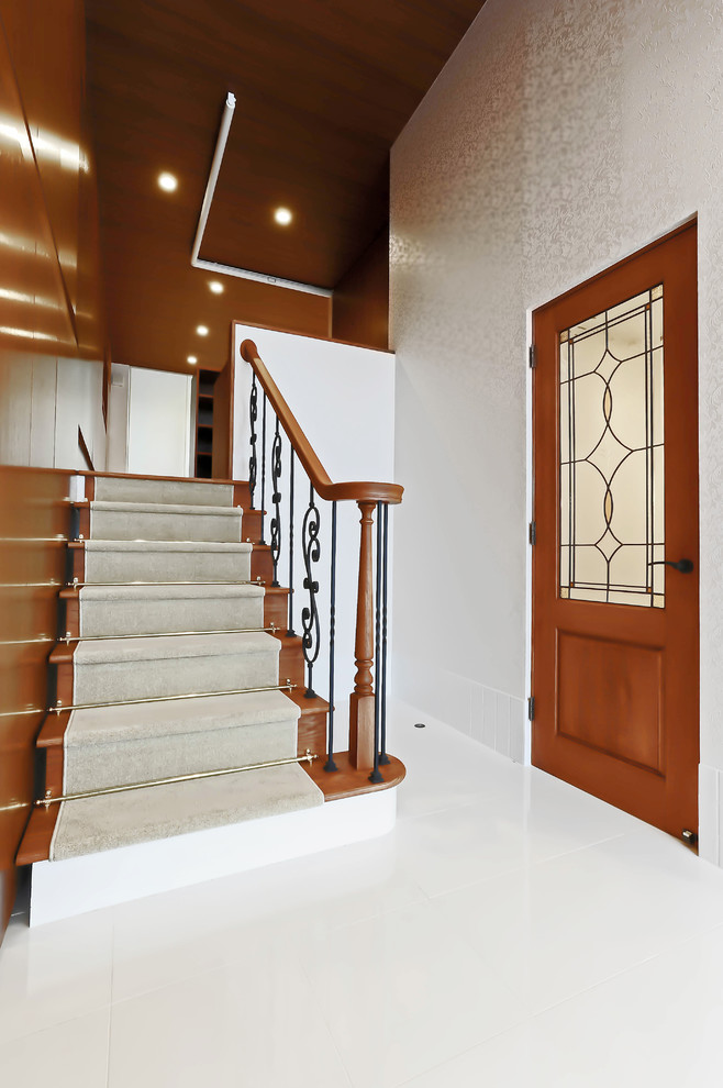 На фото: большая прямая лестница в классическом стиле с стеклянными ступенями, ковровыми подступенками и деревянными перилами с