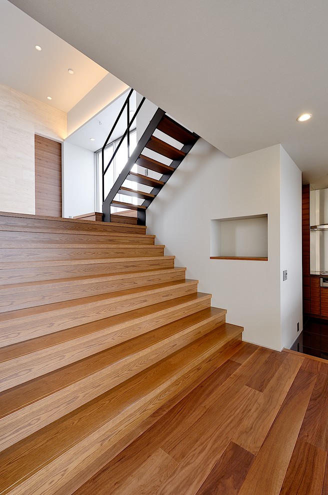 This is an example of a modern wood u-shaped staircase in Tokyo Suburbs with wood risers.