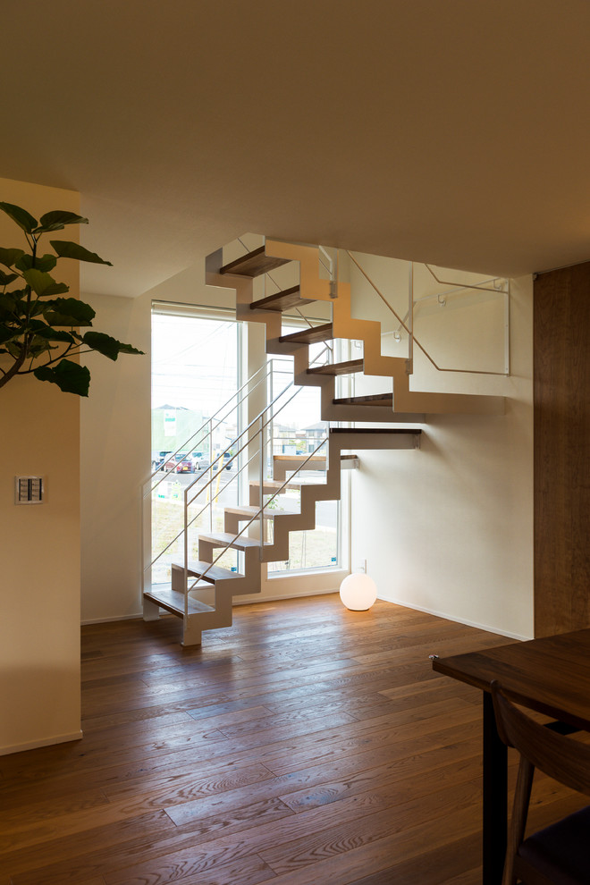 World-inspired u-shaped metal railing staircase in Other with open risers and feature lighting.