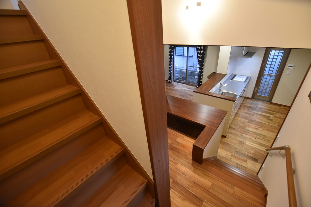 福岡にあるシャビーシック調のおしゃれな折り返し階段 (木の蹴込み板、木材の手すり) の写真