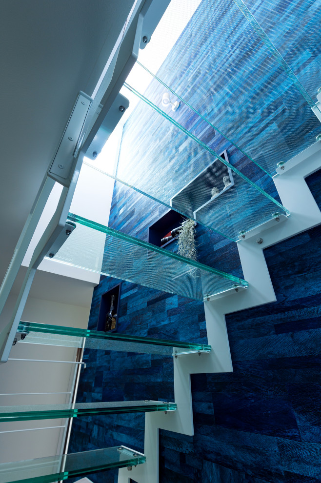 На фото: лестница в стиле модернизм с стеклянными ступенями и обоями на стенах с