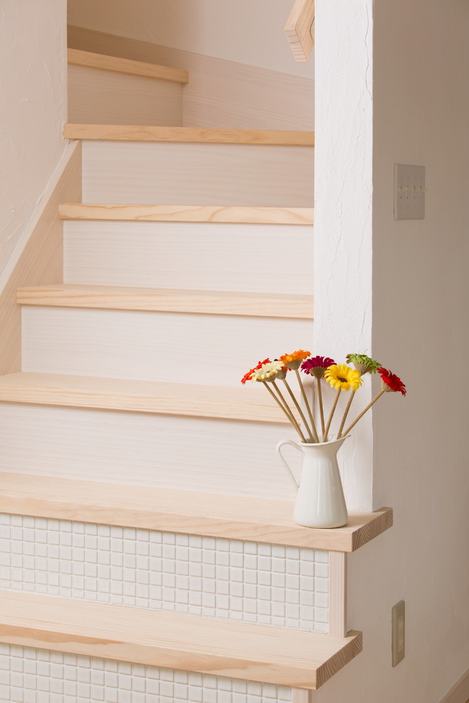 Foto de escalera en U de estilo de casa de campo con escalones de madera, contrahuellas con baldosas y/o azulejos y barandilla de madera