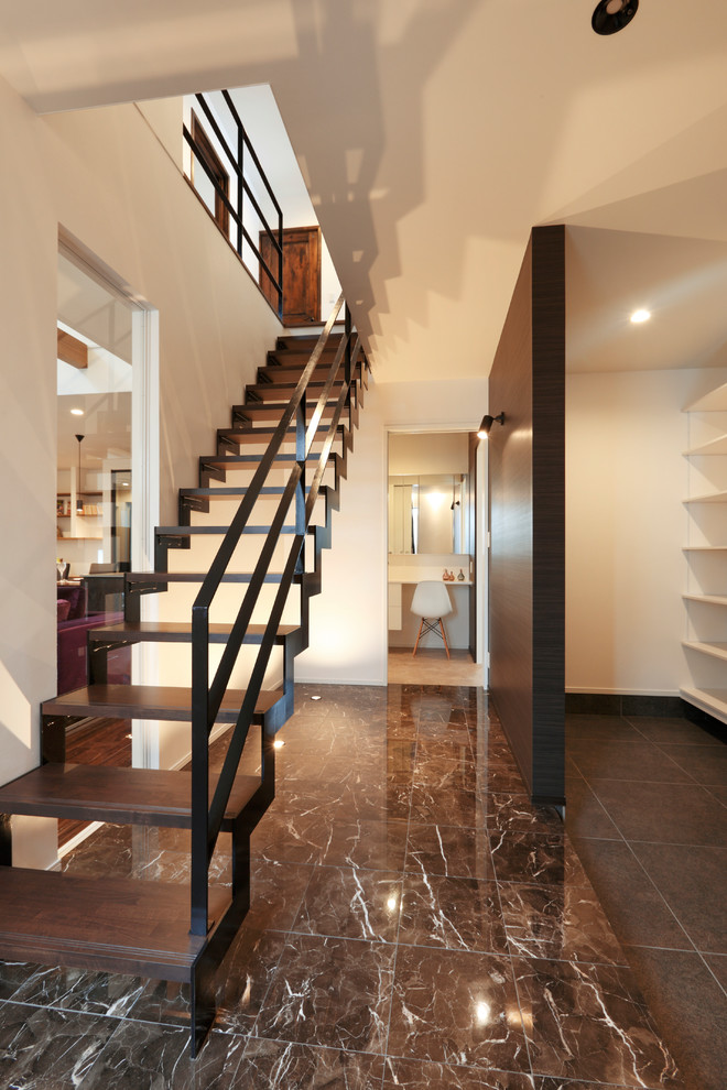 Foto de escalera recta asiática con escalones de madera y barandilla de metal