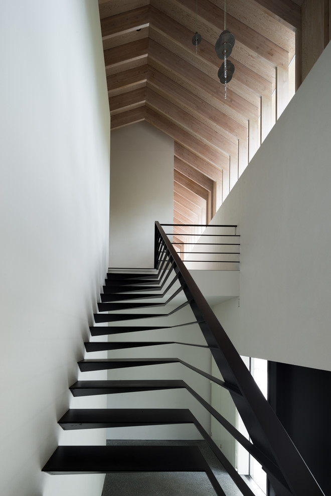 Пример оригинального дизайна: огромная прямая лестница в современном стиле с металлическими ступенями и металлическими перилами без подступенок