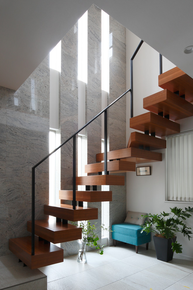 Moderne Holztreppe in L-Form mit offenen Setzstufen und Stahlgeländer in Tokio Peripherie