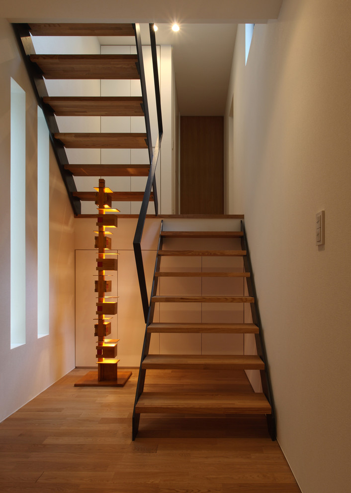 Foto de escalera de estilo zen sin contrahuella con escalones de madera y barandilla de metal