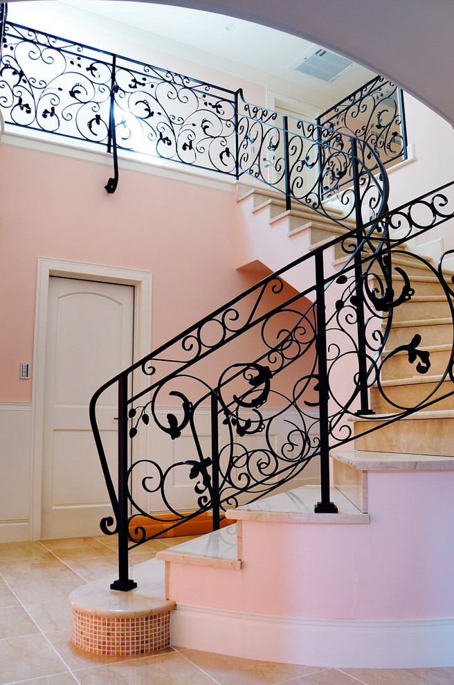 Idées déco pour un escalier courbe en marbre avec des contremarches en marbre et un garde-corps en métal.