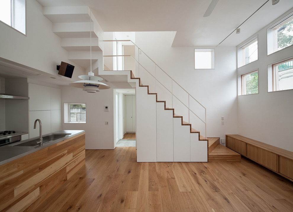 Свежая идея для дизайна: угловая деревянная лестница в стиле модернизм с деревянными ступенями и металлическими перилами - отличное фото интерьера