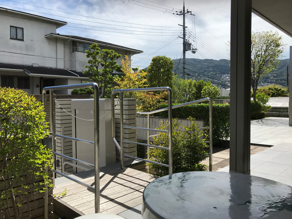 Пример оригинального дизайна: маленькая прямая бетонная лестница в стиле модернизм с ступенями из известняка и металлическими перилами для на участке и в саду