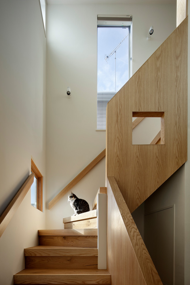 Aménagement d'un petit escalier moderne en L avec des marches en bois, des contremarches en bois et un garde-corps en bois.