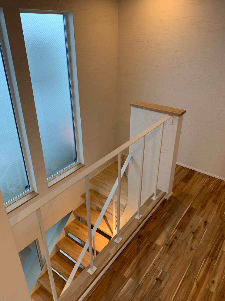 Imagen de escalera recta moderna sin contrahuella con barandilla de metal y papel pintado