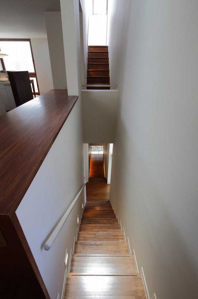 Foto de escalera recta moderna pequeña con escalones de madera, contrahuellas de madera y barandilla de madera