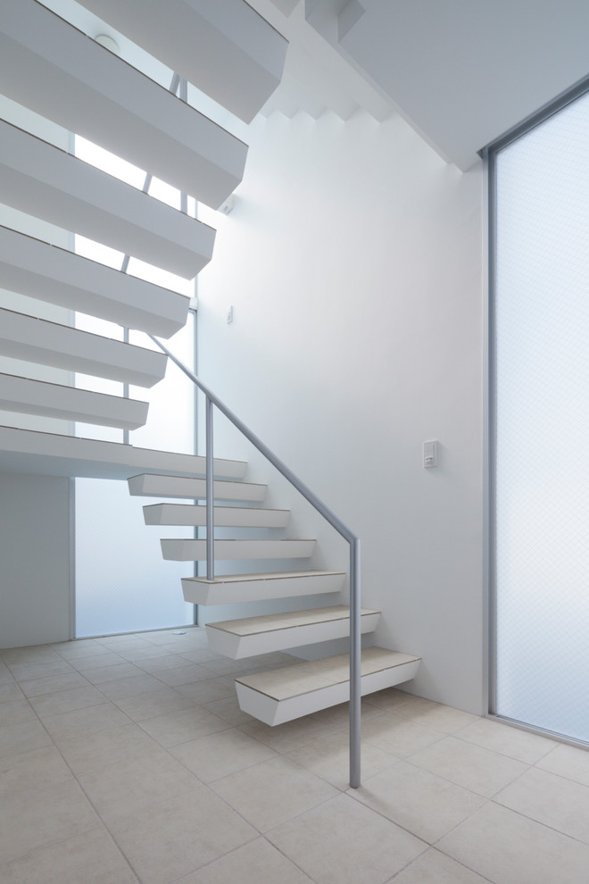 Идея дизайна: лестница на больцах в современном стиле с ступенями из плитки и металлическими перилами