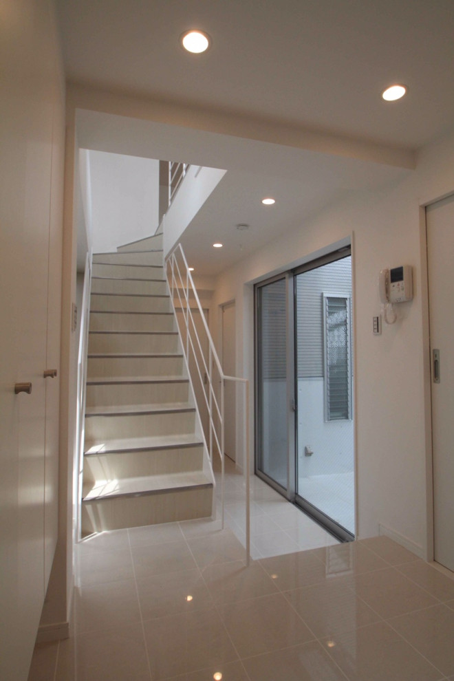 Imagen de escalera recta minimalista de tamaño medio con escalones de metal, contrahuellas de metal, barandilla de metal y papel pintado