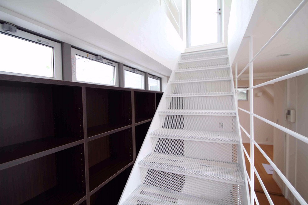 Foto de escalera recta moderna de tamaño medio con escalones de metal, contrahuellas de metal, barandilla de metal y papel pintado
