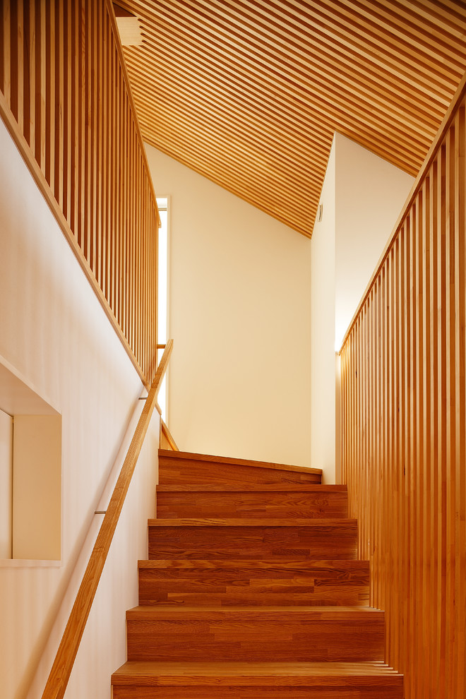 大阪にある広いトラディショナルスタイルのおしゃれな直階段 (木の蹴込み板、木材の手すり) の写真