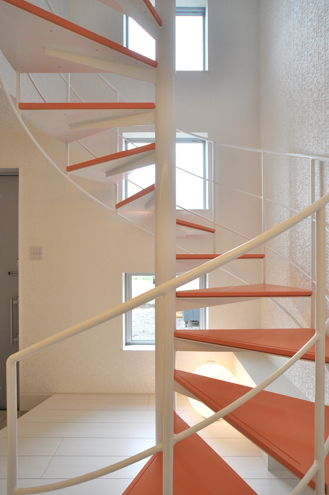 Design ideas for a modern wood spiral metal railing staircase in Other with open risers.