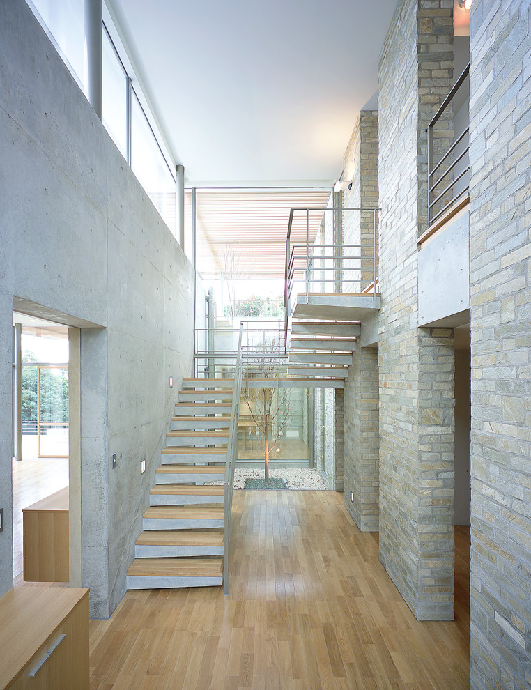 Photo of a contemporary wood staircase in Other with concrete risers.