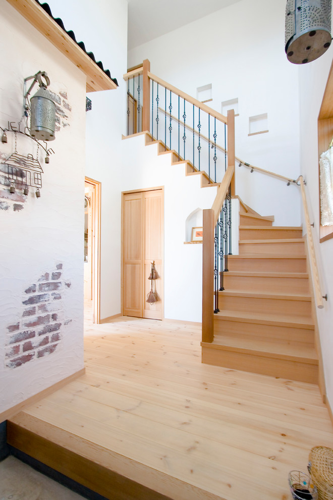 Ejemplo de escalera curva de estilo zen con escalones de madera, contrahuellas de madera y barandilla de varios materiales