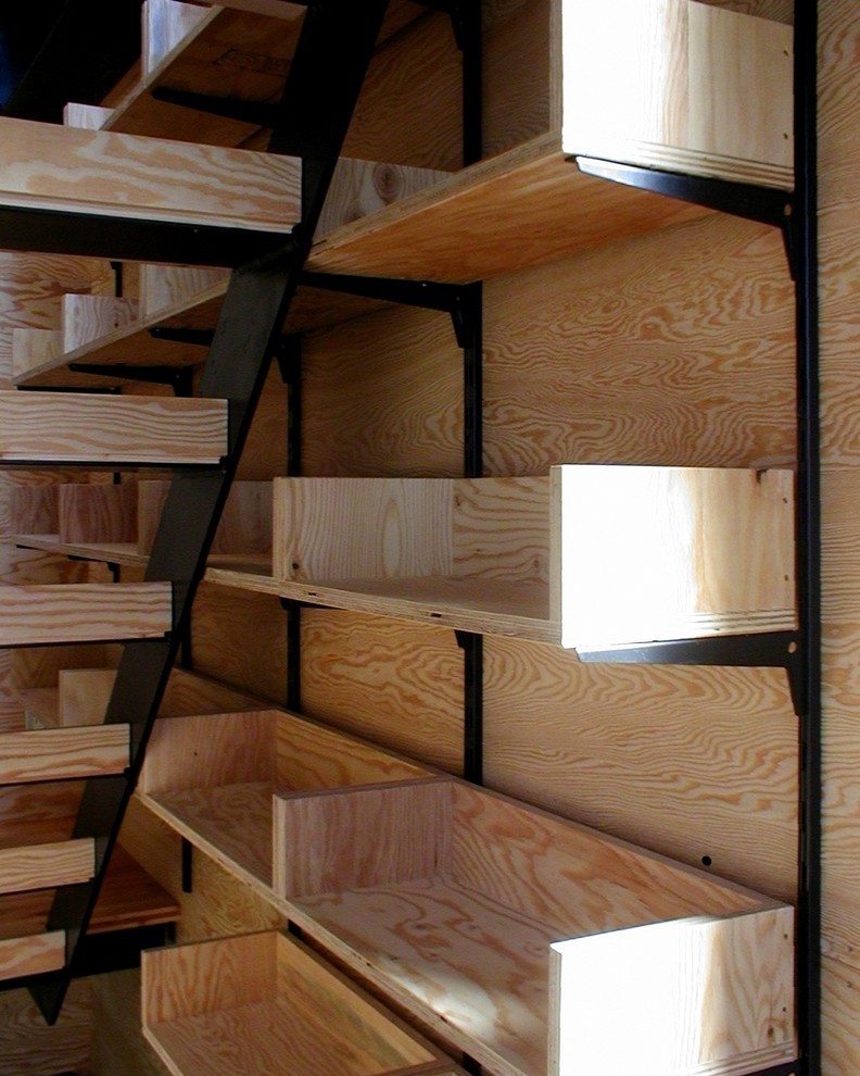 Cette photo montre un petit escalier droit industriel avec des marches en bois, des contremarches en bois et un garde-corps en bois.