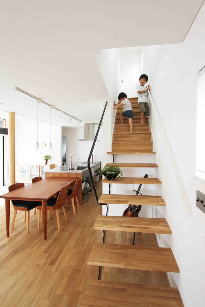 Foto de escalera recta moderna pequeña sin contrahuella con escalones de madera y barandilla de metal