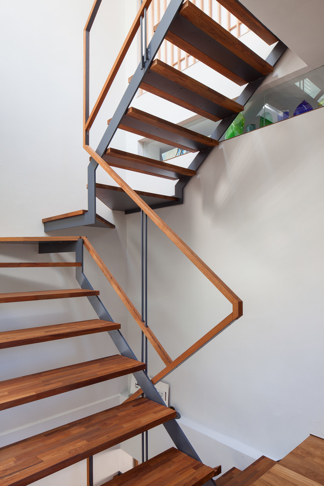 Diseño de escalera recta contemporánea sin contrahuella con escalones de madera y barandilla de madera
