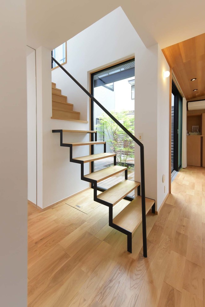Foto de escalera suspendida contemporánea sin contrahuella con escalones de madera y barandilla de metal