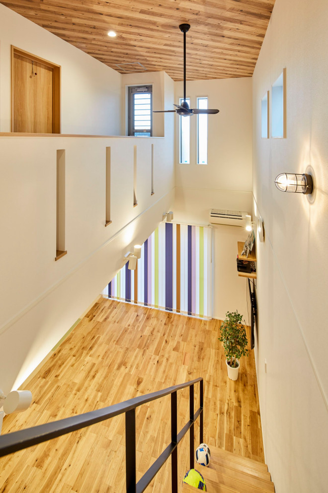 Ejemplo de escalera recta con escalones de madera, barandilla de varios materiales y papel pintado