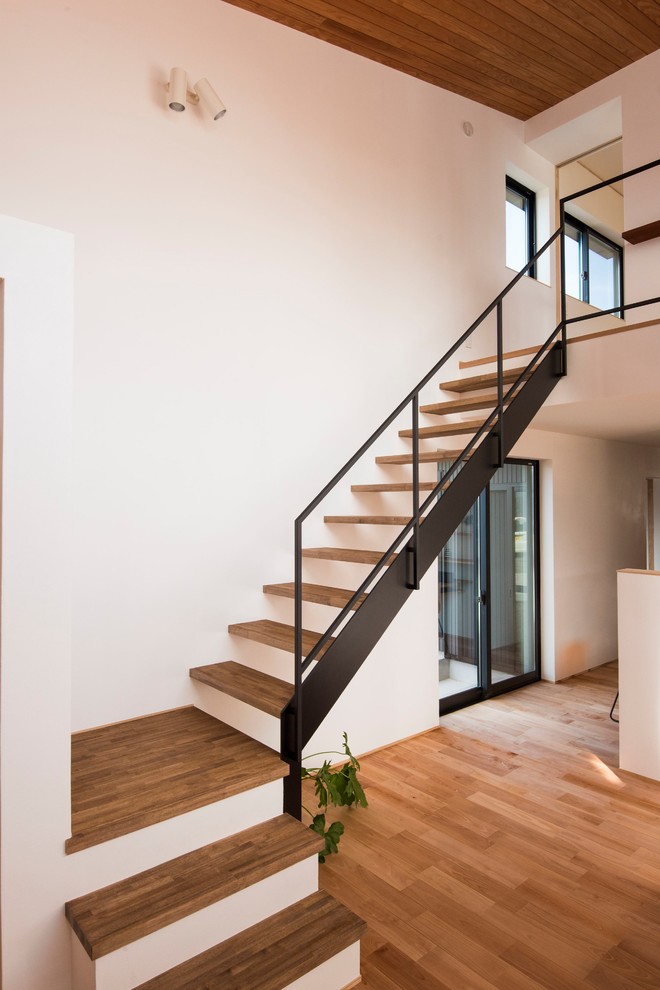 Пример оригинального дизайна: лестница на больцах в стиле модернизм с деревянными ступенями и металлическими перилами