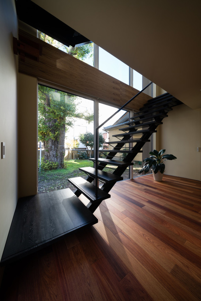 Ejemplo de escalera recta vintage sin contrahuella con escalones de madera y barandilla de metal