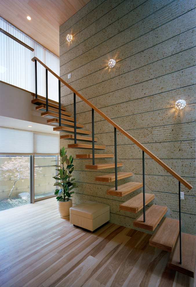 他の地域にあるコンテンポラリースタイルのおしゃれな階段 (木の蹴込み板) の写真