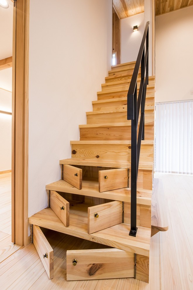 Medium sized world-inspired wood straight metal railing staircase in Other with wood risers.