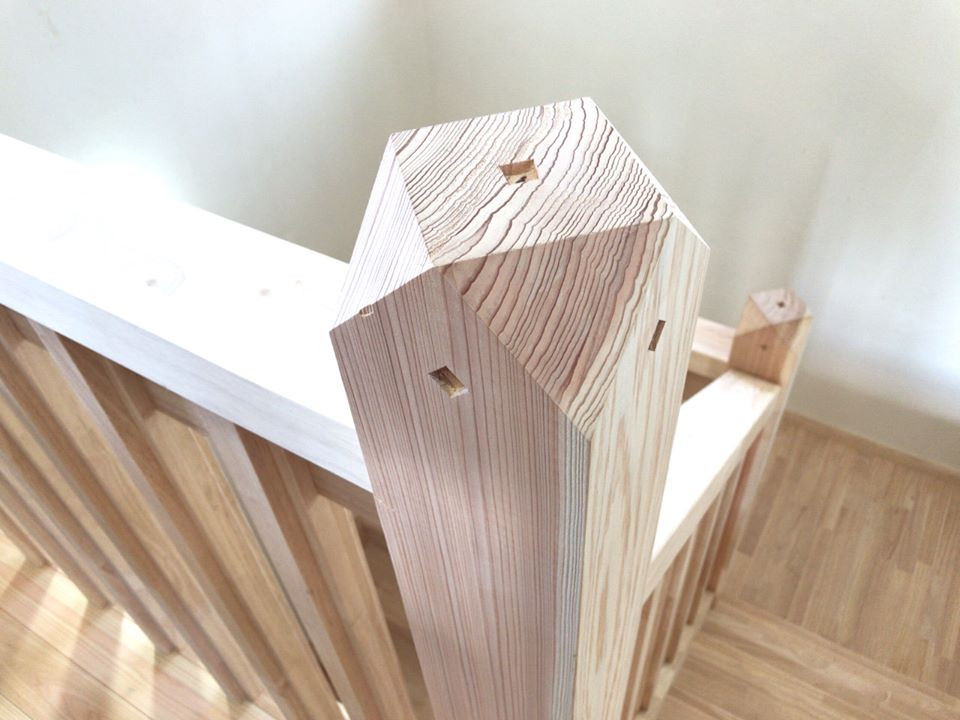 Immagine di una scala a "U" etnica di medie dimensioni con pedata in legno e parapetto in legno