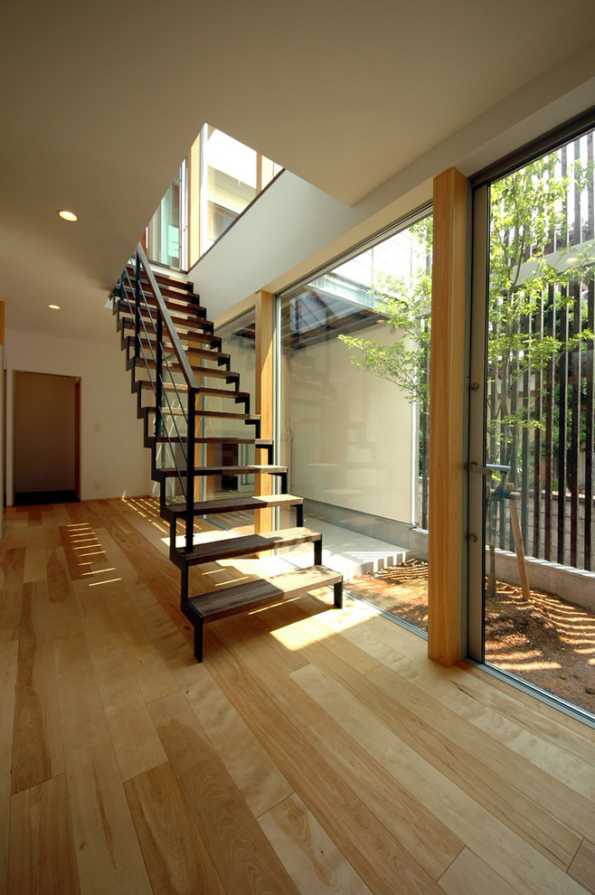 Пример оригинального дизайна: прямая лестница в восточном стиле с деревянными ступенями и металлическими перилами без подступенок