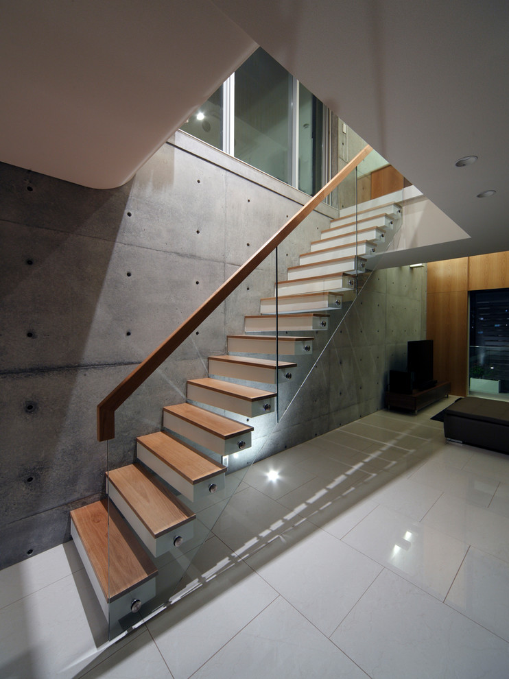 Inspiration for a contemporary wood u-shaped glass railing staircase in Osaka with wood risers.