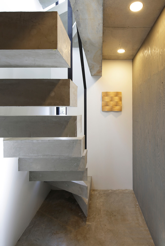 Стильный дизайн: прямая лестница в стиле лофт с бетонными ступенями и металлическими перилами без подступенок - последний тренд