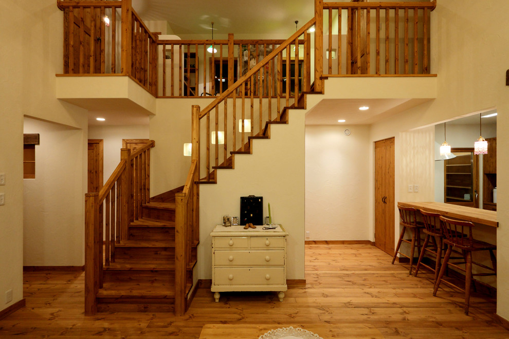 На фото: изогнутая деревянная лестница в восточном стиле с деревянными ступенями и деревянными перилами с